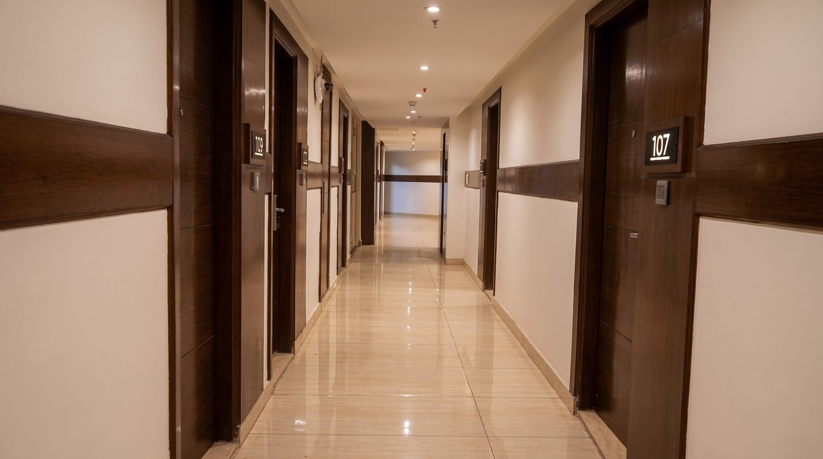 The guest corridor, doors receding toward a window