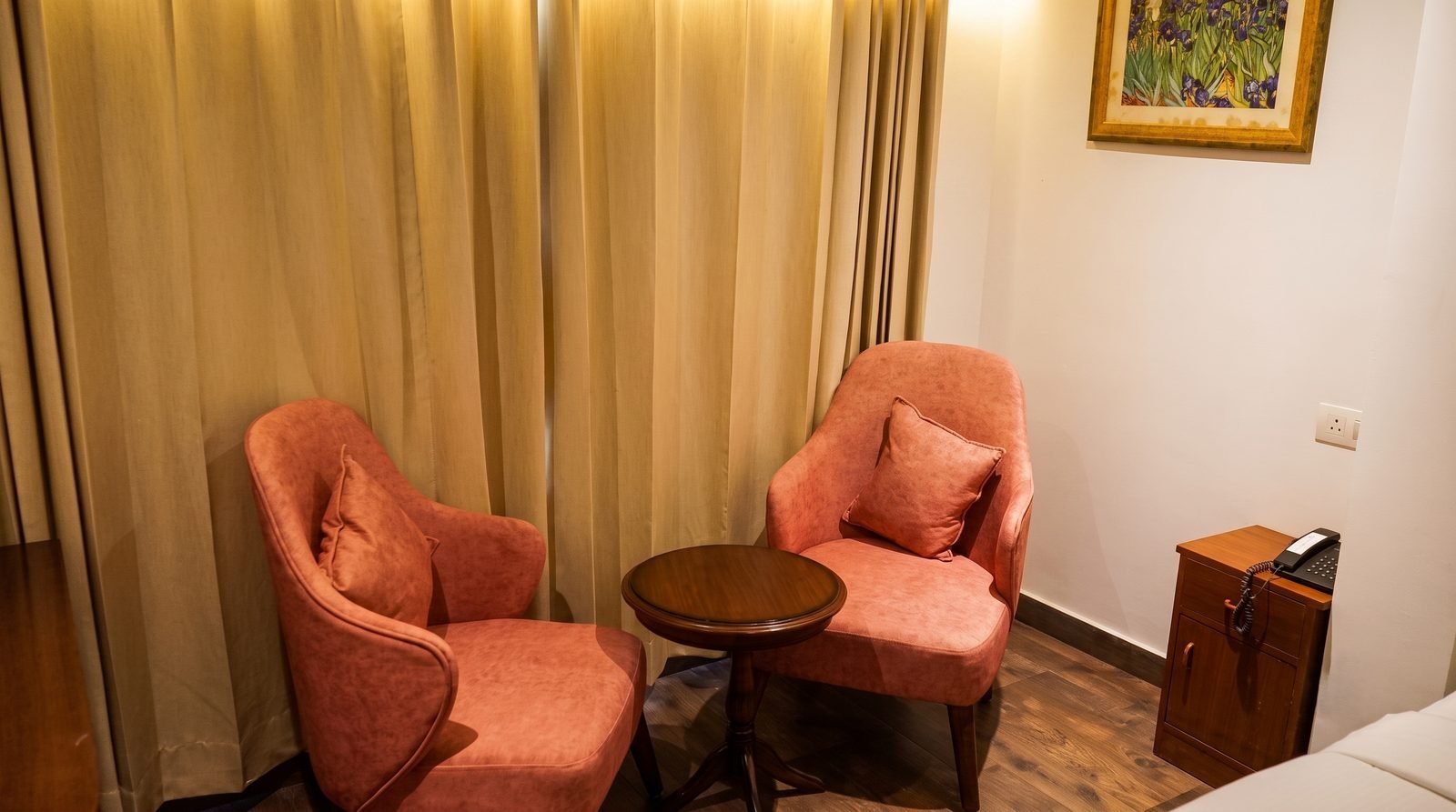 A made bed and bedside lamp in a deluxe double room