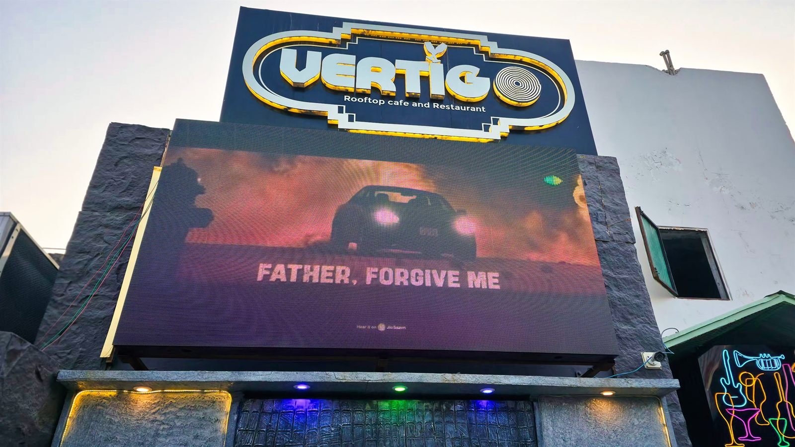 The terrace after dark, the Vertigo sign lit above the city